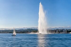 Jet d'Eau fountain rising over Lake Geneva with a sailboat